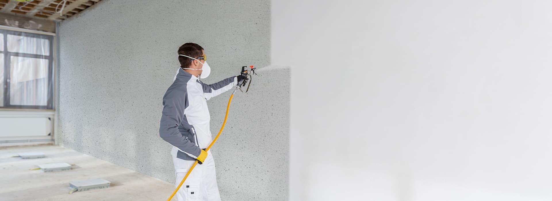 Man spraying a wall white